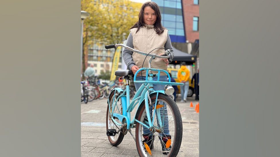 Санне с небесно-голубым велосипедом, который она выбрала в магазине велосипедов