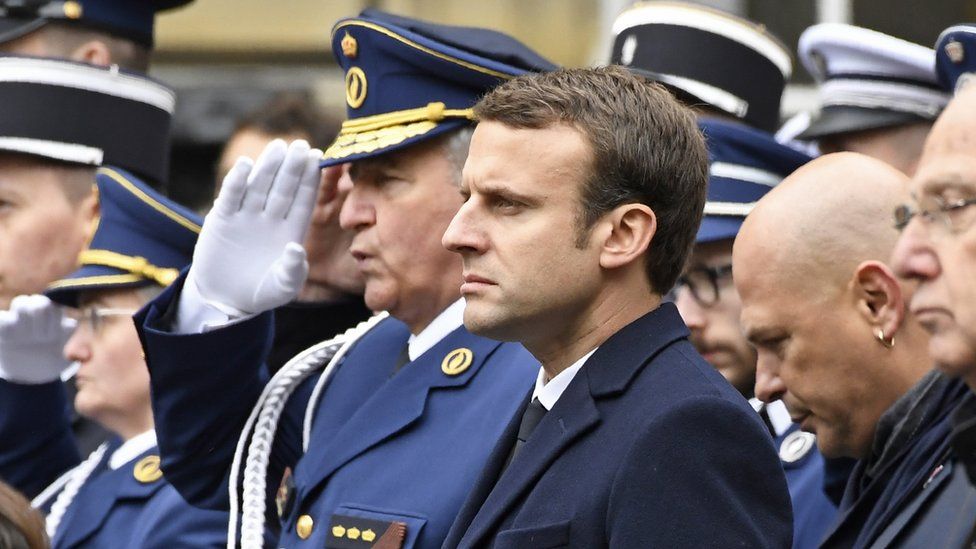 French presidential election candidate for the En Marche movement, Emmanuel Macron (C), attends a ceremony honouring the policeman killed by a jihadist in an attack on the Champs Elysees, on 25 April 2017 at the Paris prefecture building