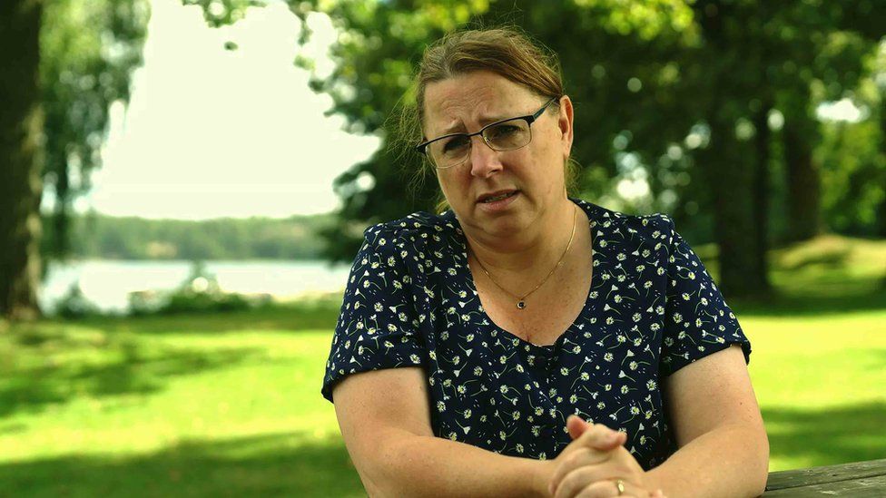 Maria, with brown hair and glasses sitting in a park