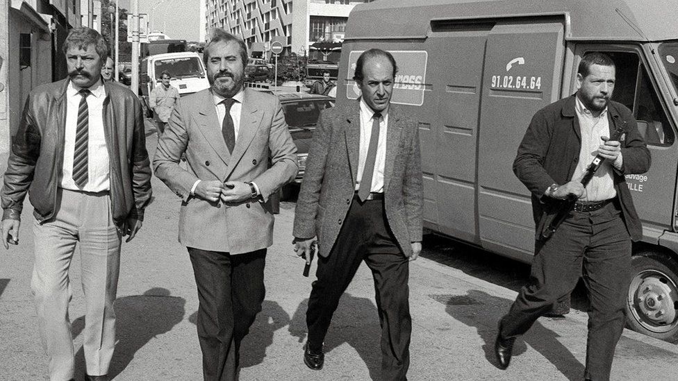 Judge Giovanni Falcone (second from left), surrounded by armed bodyguards, arrives 21 October 1986 in Marseille, France