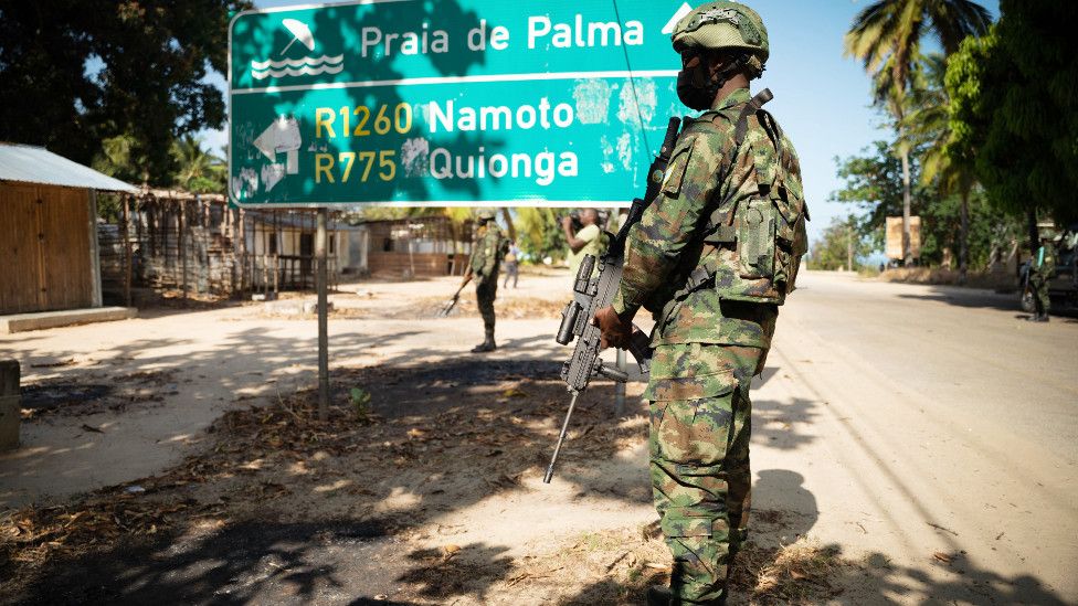 A Rwandan soldier by a sign for Palma in Cabo Delgado, Mozambique - September 2021