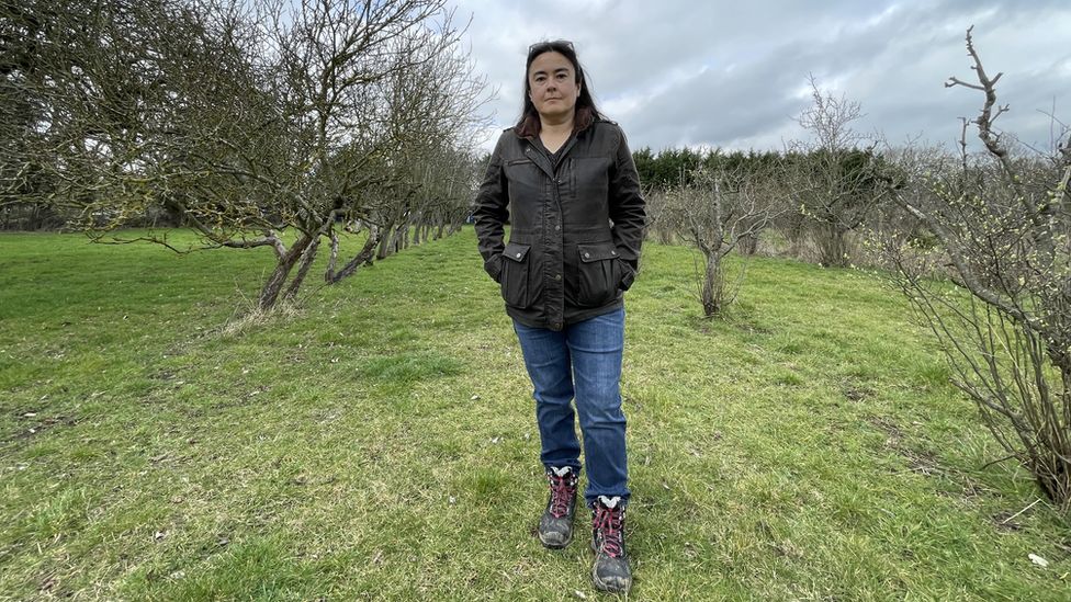 Anna Gazeley standing in an orchard