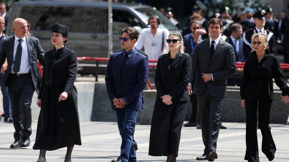 From left to right walking in a straight line, all dressed in dark clothes at their father's funeral: Eleonora Berlusconi, , Pier Silvio Berlusconi, Barbara Berlusconi, Luigi Berlusconi, Marina Berlusconi