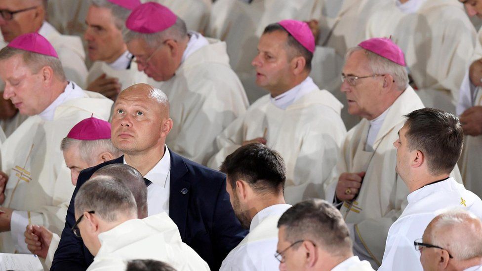 A security man among priests at the Mass - 30 July
