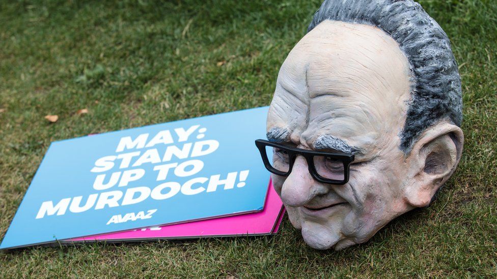 A puppet head of Australian media Mogul Rupert Murdoch sits next to placards following a photocall by campaigners from Avaaz outside the Houses of Parliament on June 29, 2017 in London, England.