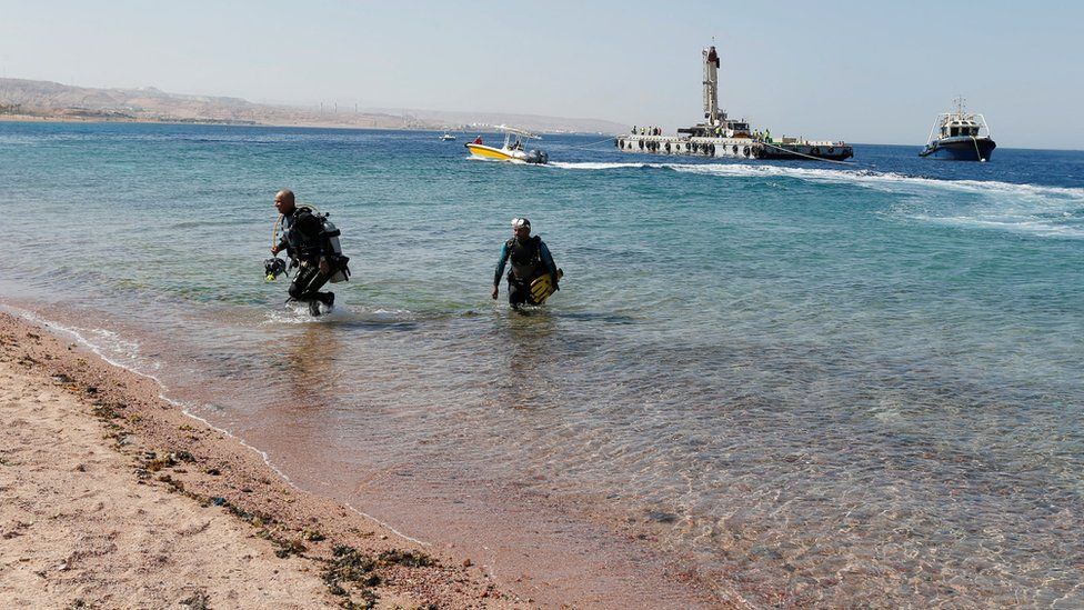 Divers get out of the water after the submerging of military vehicles in the Red Sea off Aqaba