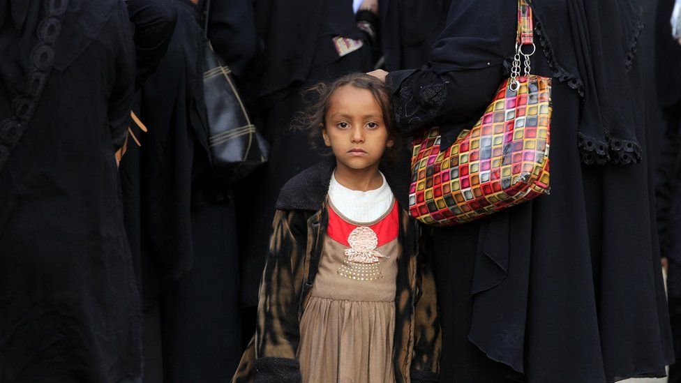 A Yemeni child stands amongst displaced people gathering to register at an evacuation centre after fleeing home due to ongoing conflict, in Sana'a, Yemen, 17 November 2018