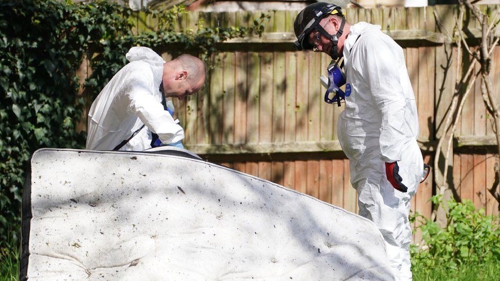 Forensics examining a mattress from the scene