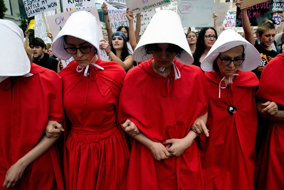 Abortion rights activists, dressed in an outfits from The Handmaid's Tale, lead protestors during a march in Denver, Colorado on 27 June 2022