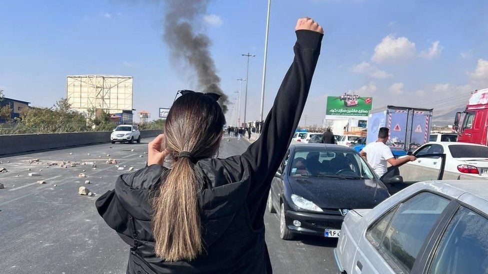 Женщина без платка держит руку во время акции протеста в иранском городе Карадж 3 ноября 2022 г.