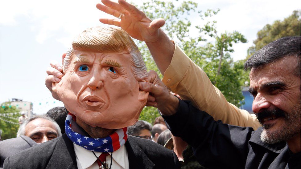 Demonstrators stand around an Iranian man that wears a mask of the US President Donald J. Trump during an anti-US rally, to show their support of Iran's decision to pull out from some part of nuclear deal, in Tehran, Iran, 10 May 2019.