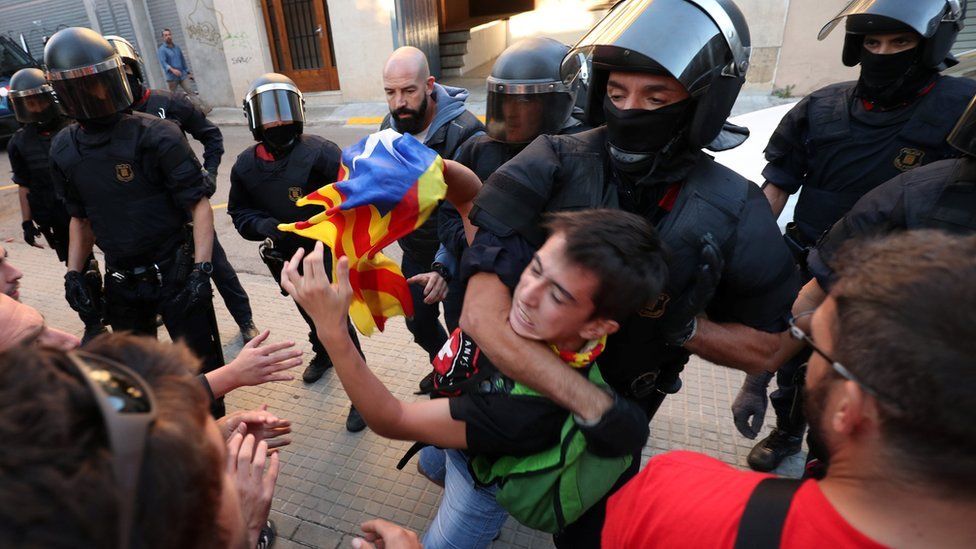 Police remove a protester outside Unipost office in Terrassa on 19 Sept