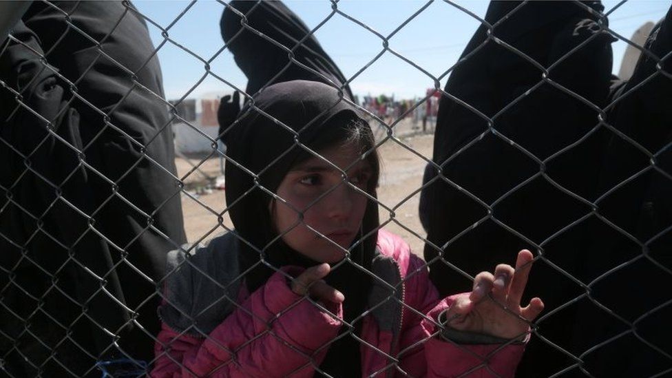 A girl looks through a chain linked fence at al-Hol displacement camp in Hasaka governorate, Syria on 8 March 2019