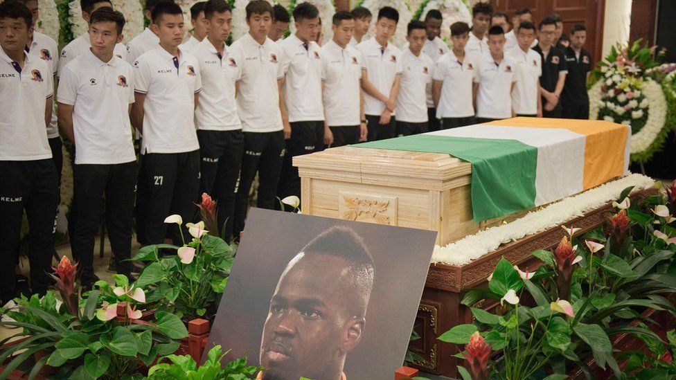 Beijing Enterprises club football players look at the coffin of Cheick Tiote during a memorial service in Beijing on June 13, 2017. Tiote, who was a member of the Ivory Coast squad that ended a 23-year drought to win the 2015 Africa Cup of Nations, died on June 5, 2017 after "suddenly fainting" during a training session with his second tier Chinese club Beijing Enterprises.