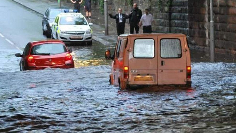 Vehicles stuck in standing water under a bridge