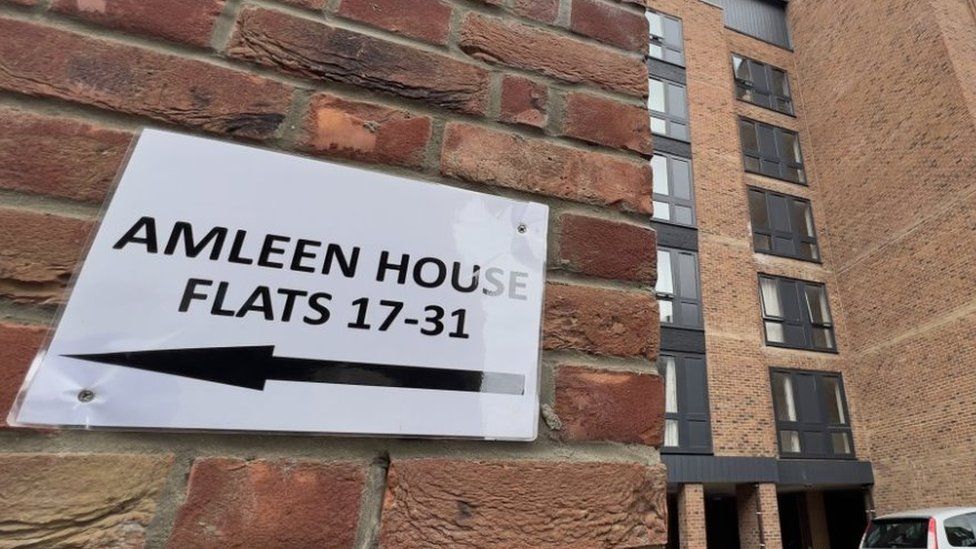 Sign on a residential block showing flat numbers
