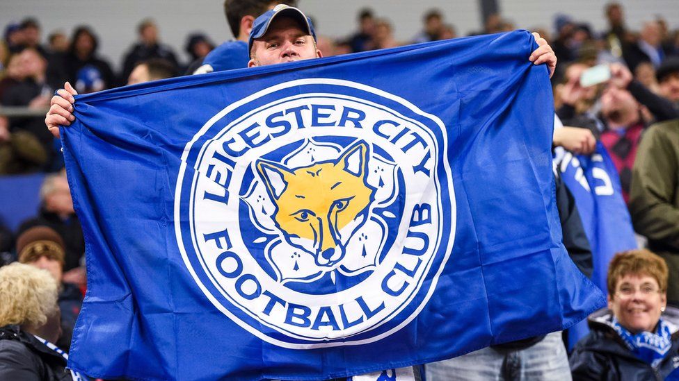 Leicester City fan with a flag and the club logo