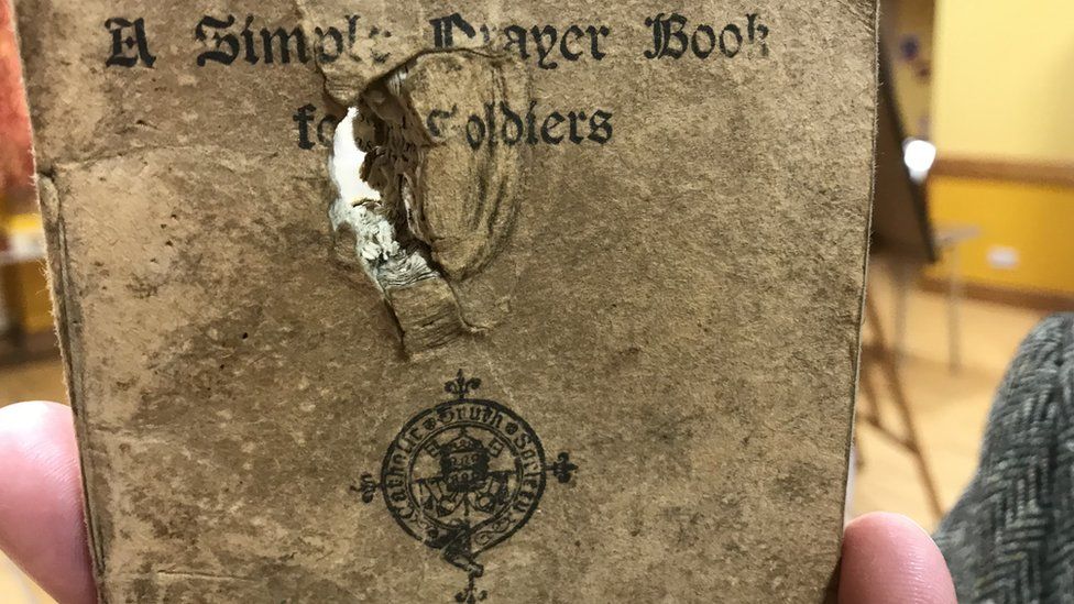 A close up of the prayer book with the bullet hole