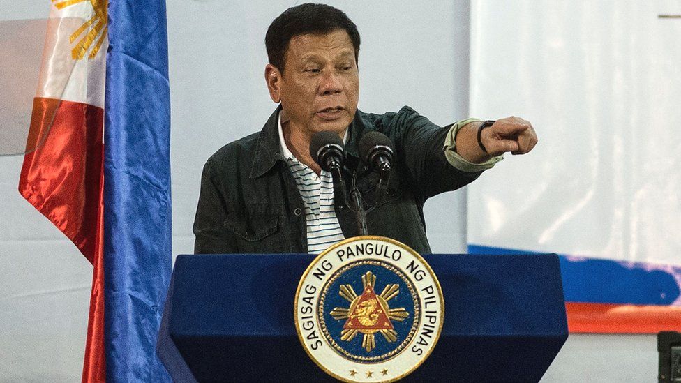 Philippine President Rodrigo Duterte gestures to a crowd at a conference, 30 June 2016