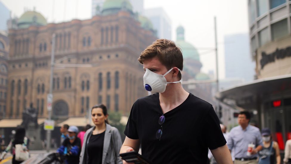 A man wears a face mask to protect himself against the smoke while walking through Sydney's centre on Tuesday