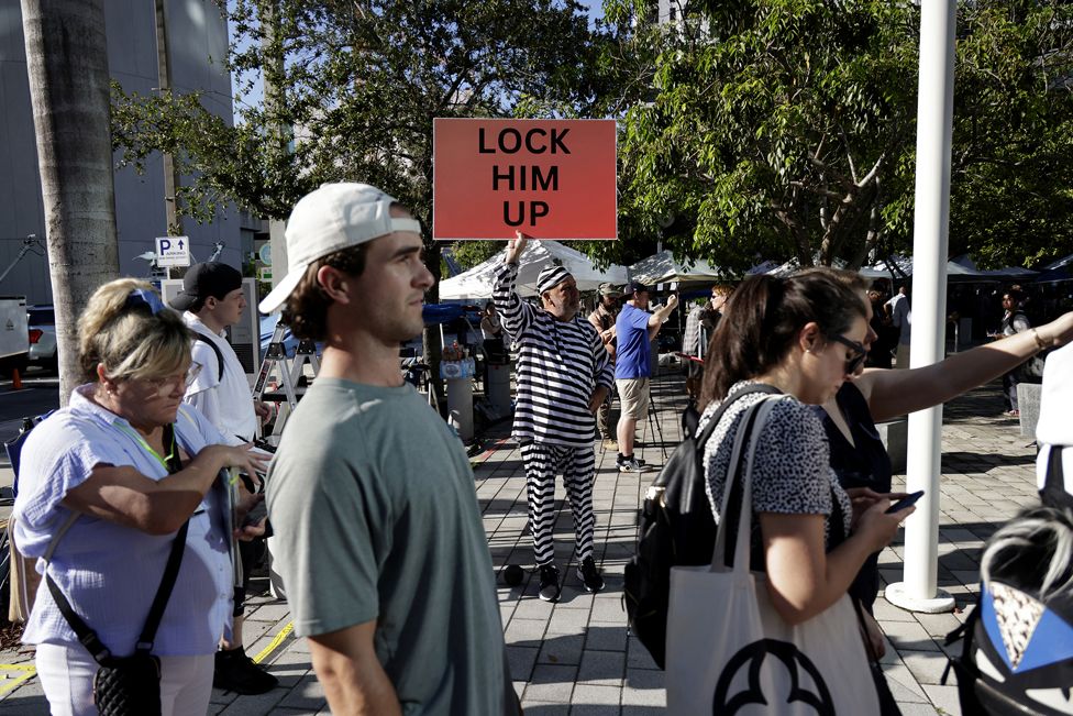 A Trump opponent holds a sign outside the Wilkie D. Ferguson Jr. United States Federal Courthouse where former President Donald Trump is set to appear in front of a judge on June 13, 2023 in Miami, Florida
