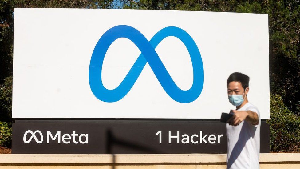 A man takes a selfie in front of a sign for "Meta", the new name for Facebook's parent company, outside Facebook headquarters in Menlo Park on 28 October 2021