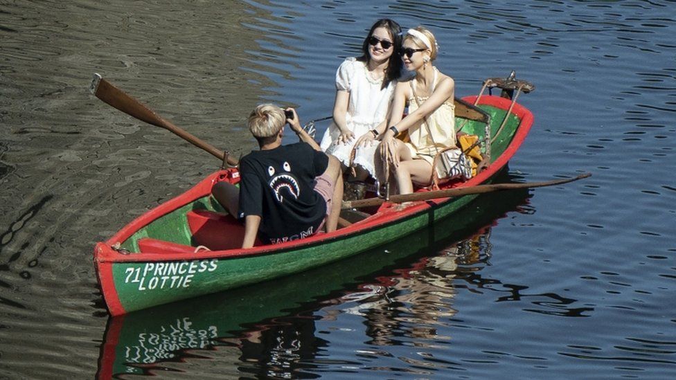 People in a row a boat enjoy the hot weather on the River Nidd in Knaresborough, North Yorkshire