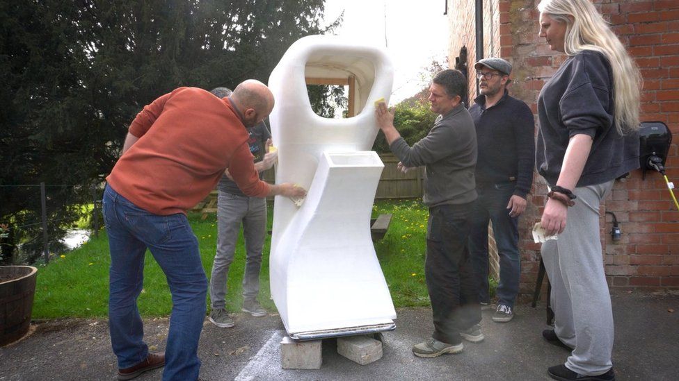 A team of people sanding the 3D model