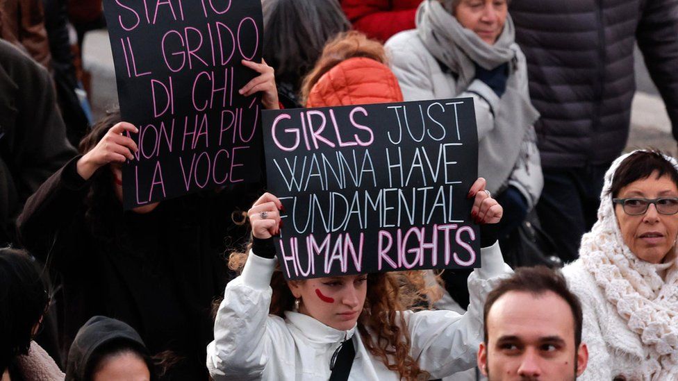 Female protester holding a sign that reads girls just wanna have fundamental human rights during demonstrations in Rome