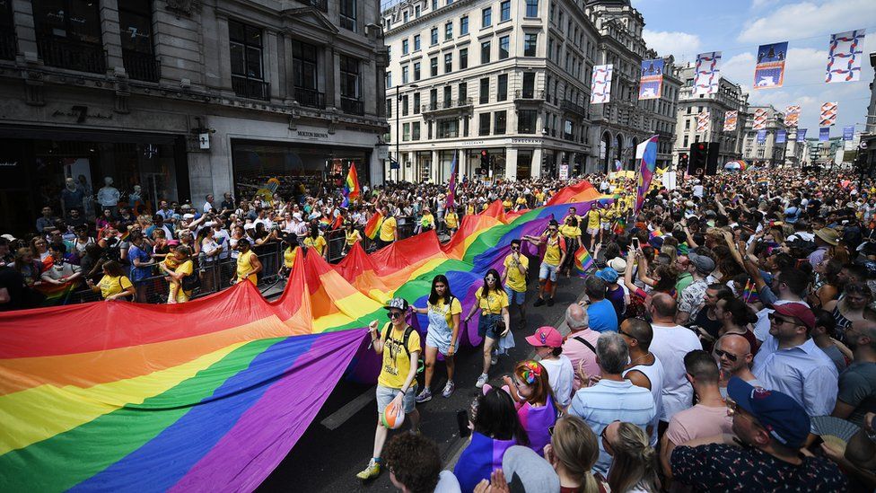 Participants carry a giant Rainbow flag as tens of thousands of people attend the annual London Pride Parade in