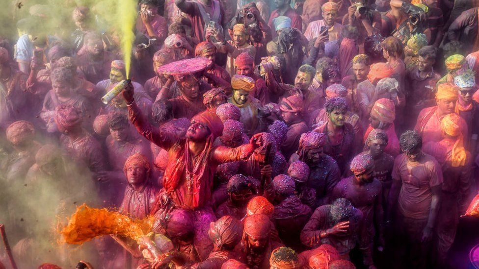 MATHURA, INDIA - 2023/03/01: Hindu devotees play with colorful powders (Gulal) at the Radharani Temple of Nandgaon during the festival. Holi Festival of India is one of the biggest colorful celebrations in India as many tourists and devotees gather to observe this colorful event. At the beginning of spring, the festival celebrates the divine love of Radha and Krishna and represents the victory of good over evil.