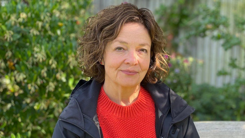 Julia Walters, a woman with brown hair, brown eyes and a red jumper