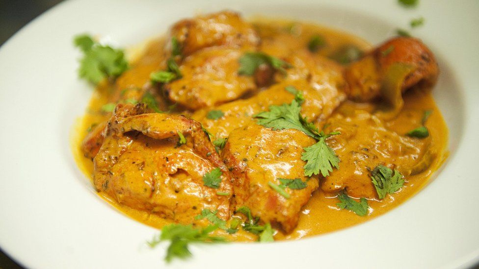 A plate of Chicken Tikka Masala curry in a restaurant