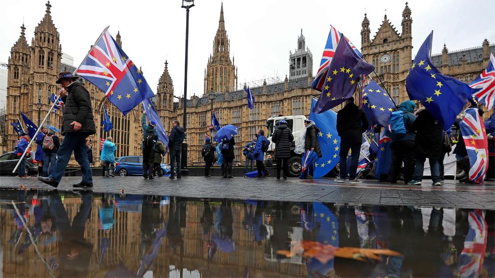 Anti-Brexit demonstrators wave Union Jacks and EU flags opposite the Houses of Parliament on 3 December