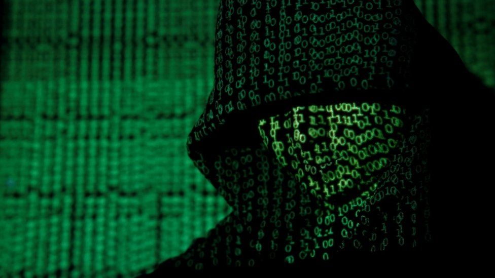Projection of cyber code onto a hooded man