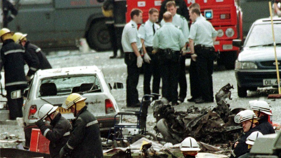 Royal Ulster Constabulary police officers and firefighters inspecting the damage caused by a bomb explosion in Market Street, Omagh, August 15th 1998