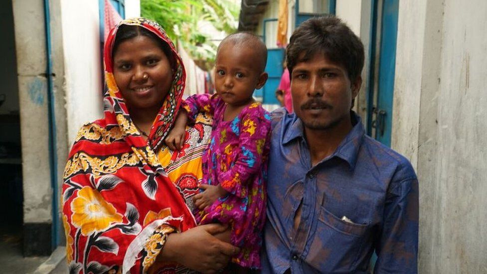 Picture of young pneumonia survivor and her parents outside home