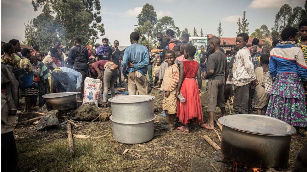 Добровольцы готовят еду для внутренне перемещенных лиц, спасающихся от недавних столкновений между повстанцами «М23» и конголезскими солдатами, в лагере в Каньярушинья к северу от Гомы.