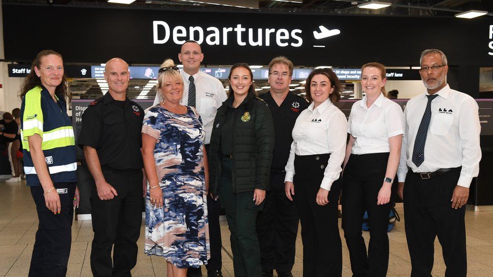 The team who helped deliver the baby pose together at the departures lounge