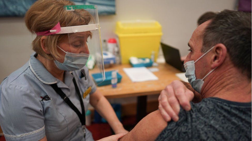 A key worker receives the vaccine in the UK
