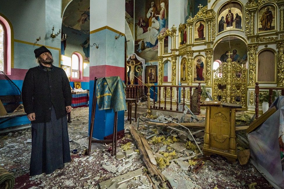 The priest of Yasnohorodka, stands inside his church destroyed because the combats between the Russian and Ukrainian armies