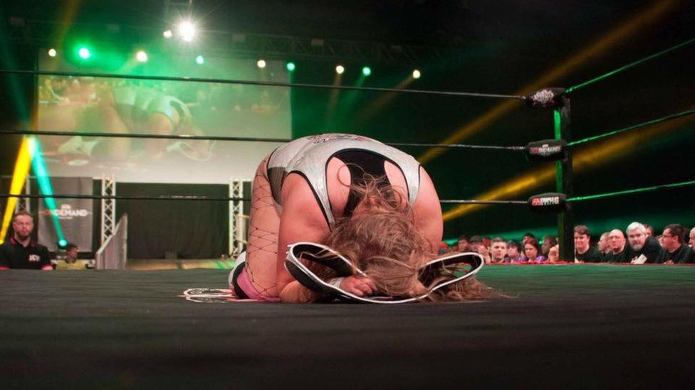 woman with wrestling belt in ring