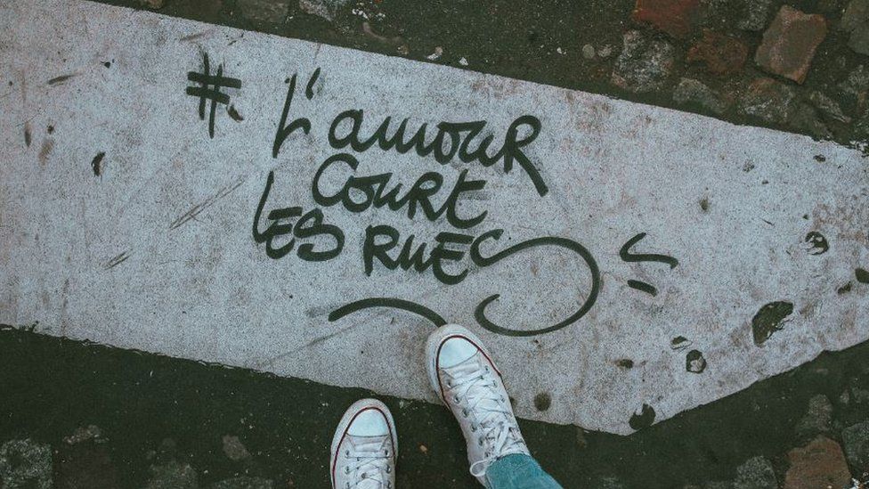 Graffiti tag "L'amour court les rues" or "Love runs the streets"