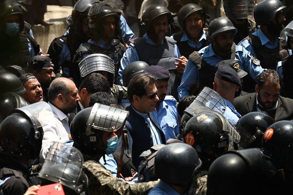 Police escort former Pakistan's Prime Minister Imran Khan (C) as he arrives at the high court in Islamabad on May 12, 2023.