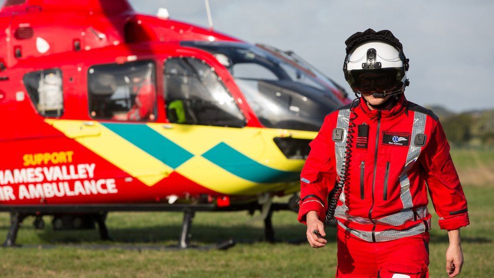 Thames Valley Air Ambulance staff member with helicopter