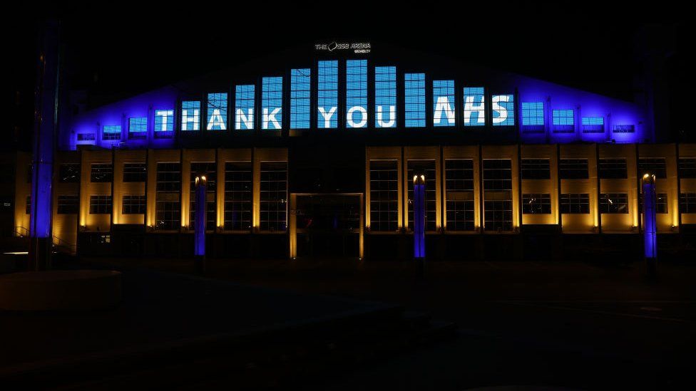 LONDON, - MARCH 26: The Wembley arena is lit up thanking the NHS on March 26, 2020 in London, United Kingdom. The "Clap For Our Carers" campaign has been encouraging people across the U.K to take part in the nationwide round of applause from their windows, doors, balconies and gardens at 8pm to show their appreciation for the efforts of the NHS as they tackle the coronavirus (COVID-19).