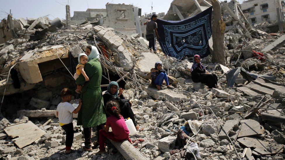 Members of the al-Kafarna family inspect the rubble of their destroyed house in Beit Hanoun, northern Gaza, on 1 August 2014