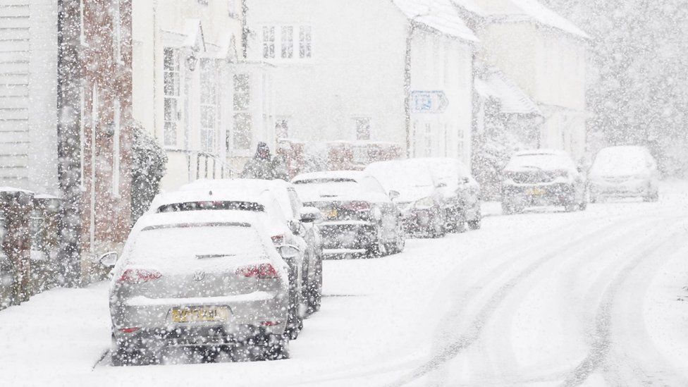 Cars parked during a snow flurry in Lenham, Kent
