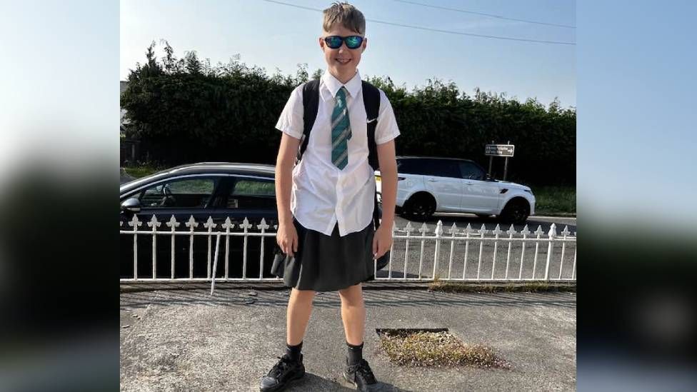 School uniform: Boy wears skirt in shorts ban protest - BBC News