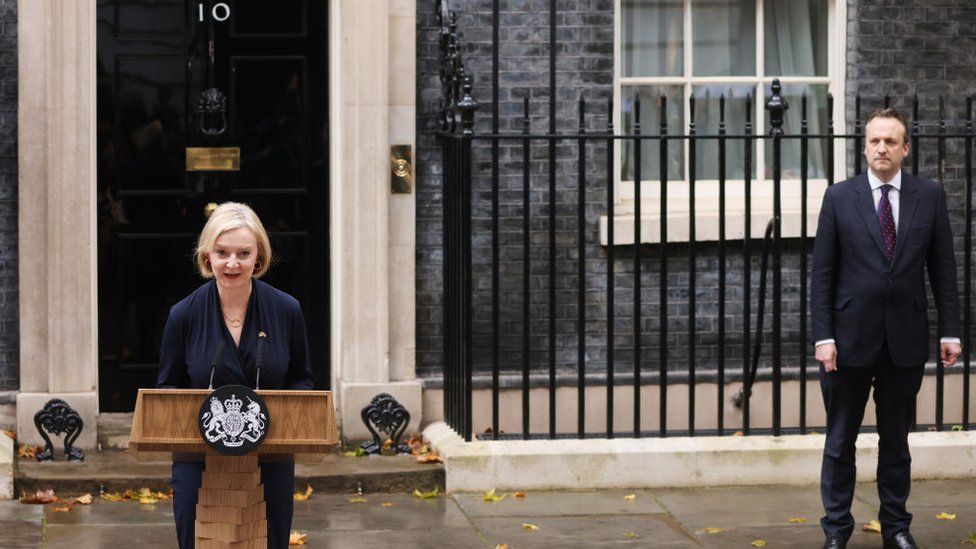 Liz Truss speaks in Downing Street, watched by husband Hugh O'Leary, as she resigns as Prime Minister
